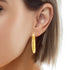 Close-up of a woman's ear showcasing the Beautiful Texturized Hoops Earrings, which are 4cm round and made from 14k gold-filled material, guaranteeing a lead and nickel free experience.